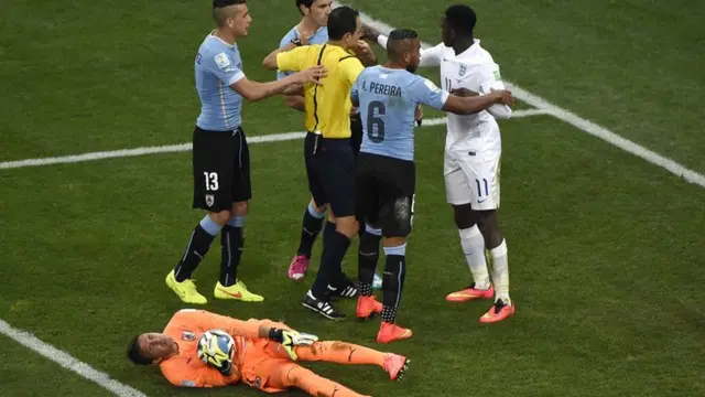 Uruguay keeper Fernando Muslera lies in a heap after Welbeck's challenge