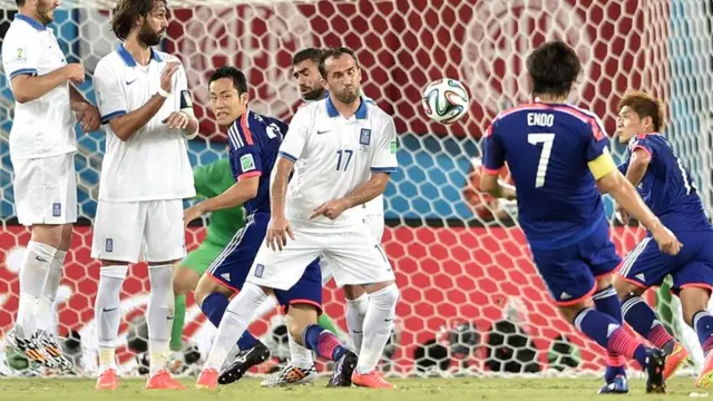 Yashuhito Endo curls a free-kick over the Greece wall