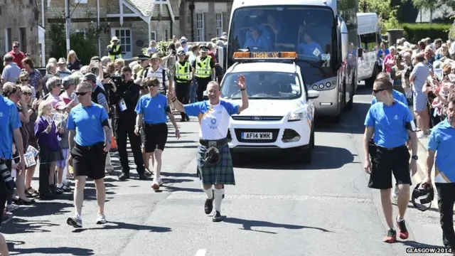 Grant Young carries the Queen's baton in Alloway