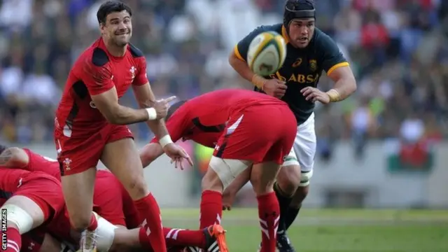 Wales scrum-half Mike Phillips (L) clears the ball out of a scrum during