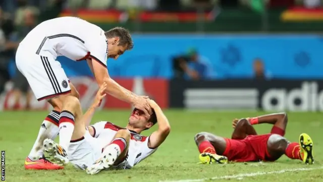 Thomas Mueller of Germany lies injured on the field after a collision with John Boye