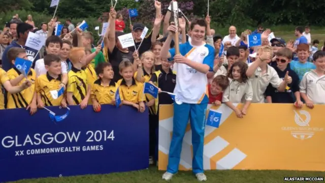 Young baton bearer with crowd of children