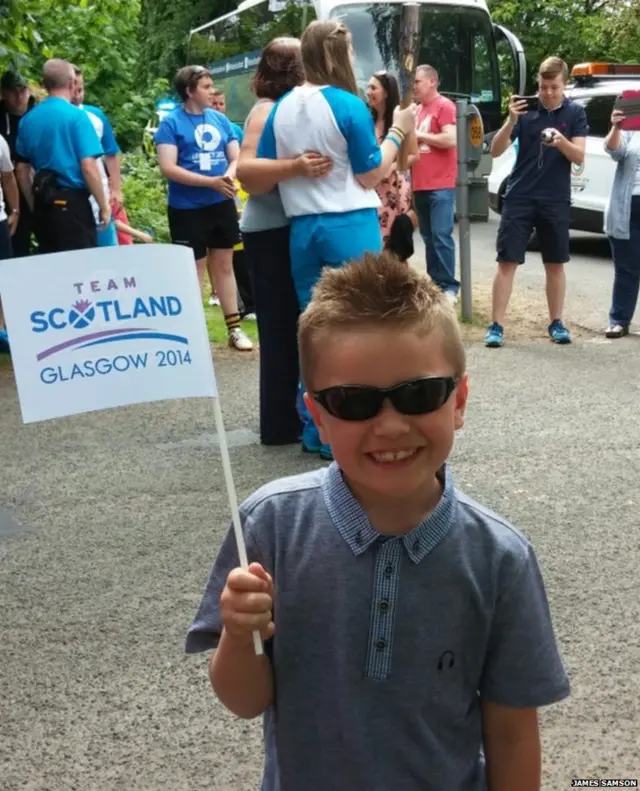 Smiling young boy waving a 'Team Scotland' flag