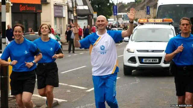 Gary Balfour runs with baton