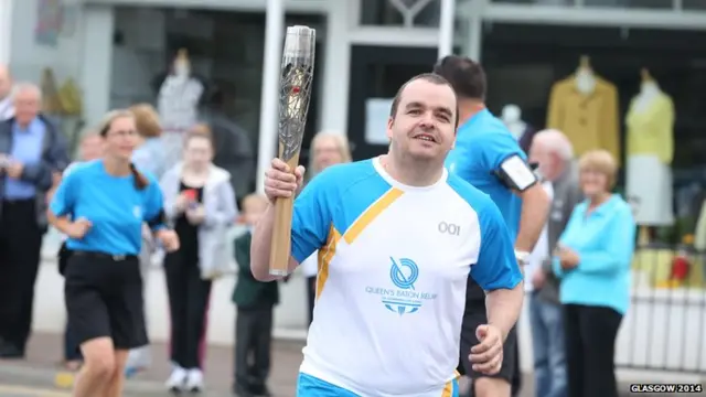 Our first baton bearer of the day Stuart Crawford runs proudly with baton in Denny.