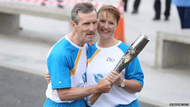 We are flying through the baton bearers in Larbert as Alan Miller hands the baton Amanda Rutherford.