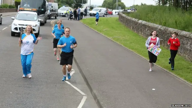 Kirsty Fannon's supporters run alongside her carries the baton