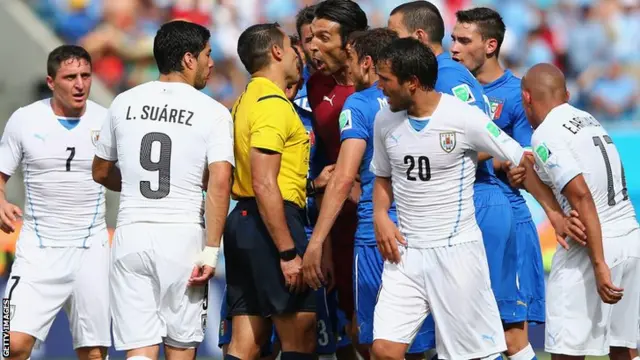 Italy players surround the referee