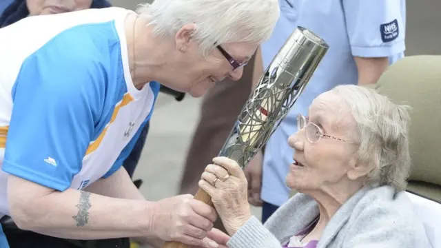 Rose McLellan-Dally shows the Queen's Baton to Annie Morton