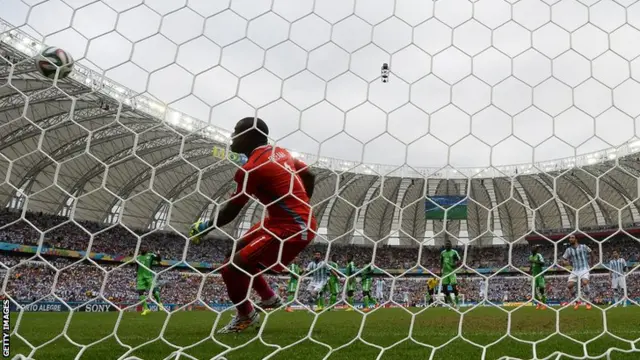 Lionel Messi scores his second of the game as the Nigeria keeper looks on