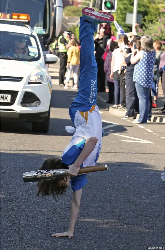 Rebecca Stewart does one handed cartwheel while holding baton