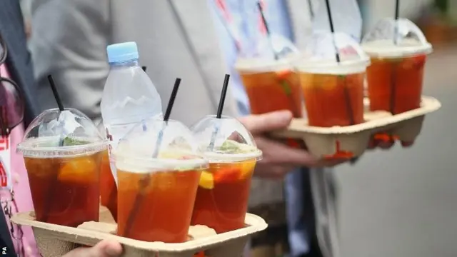 Spectators carrying glasses of Pimms