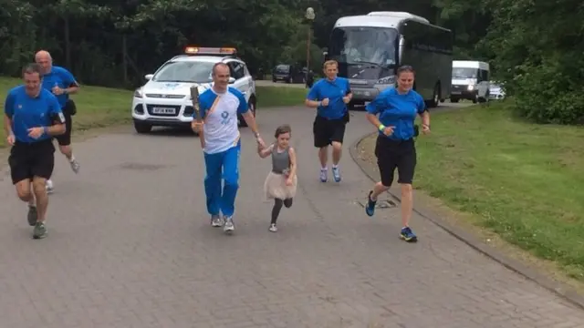 Ross McGuire and daughter run with the baton