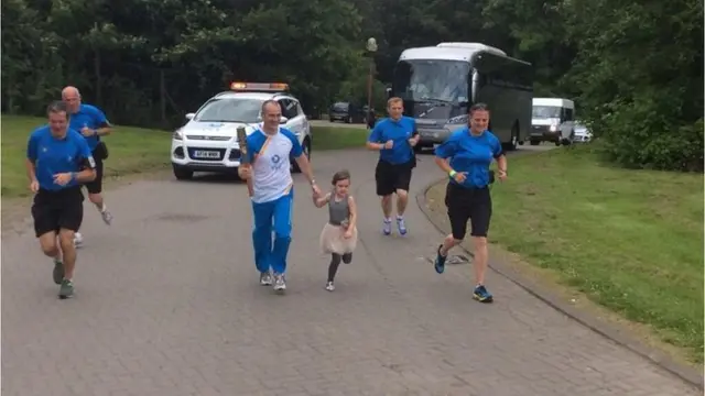 Ross Maguire's daughter Lana run alongside her proud dad during his time with baton in Caird Park.