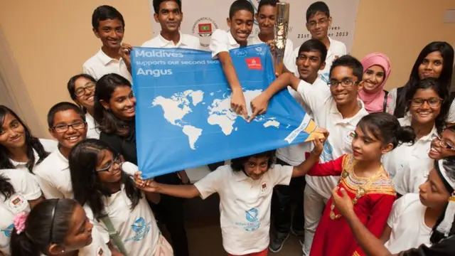 Maldives children hold a support a second team banner