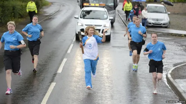 Jennifer Sandeman carries the Glasgow 2014 Queen's Baton through Glamis in Angus.