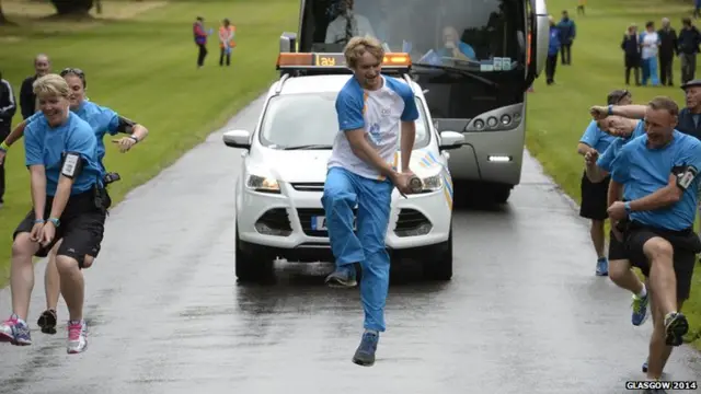 Stewart Watson jumps with Queen's baton