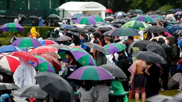 Spectators shelter from the rain