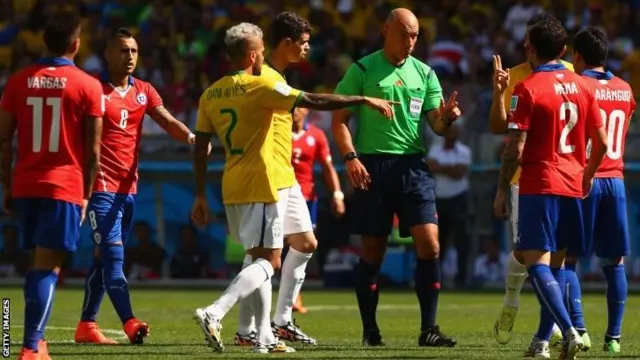 Players surround Howard Webb