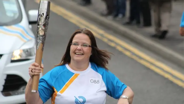 Kerry Walker runs with the baton