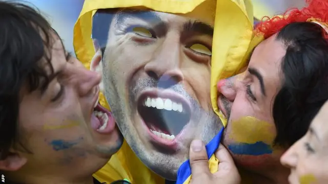 Colombia fans bite a Luis Suarez mask