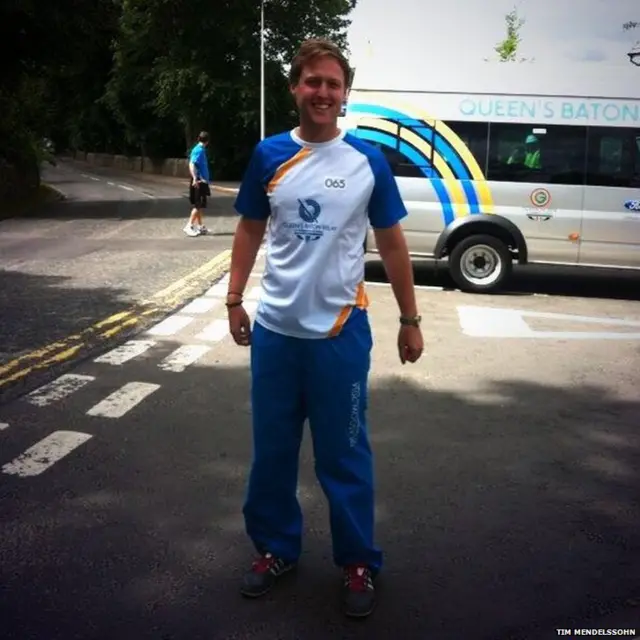 Tim Mendelssohn stands in front of Baton Relay bus