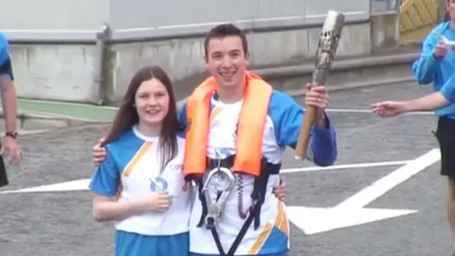 Baton bearer wearing lifejacket and other survival gear