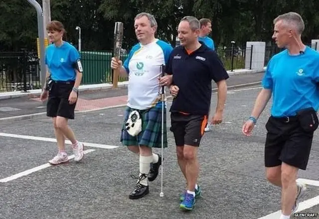 Visually impaired Colin Middler carries the baton guided by Carl Hodson