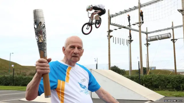 Bill Berry with BMX rider in mid-air behind him