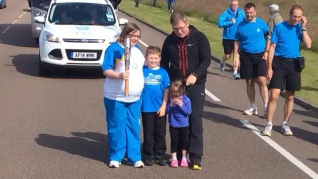 Lesley MacPherson with her family and the baton