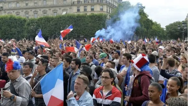 France supporters waves French flags as they watch the 2014 FIFA World Cup round of 16 football match between France and Nigeria on a giant screen at the Hotel de Ville (City Hall) in Paris