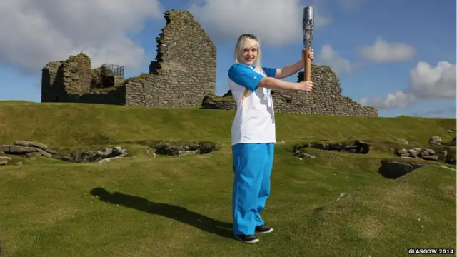 Ceileidh Mercer carries the Glasgow 2014 Queen's Baton through Sumburgh on the Shetland Islands.