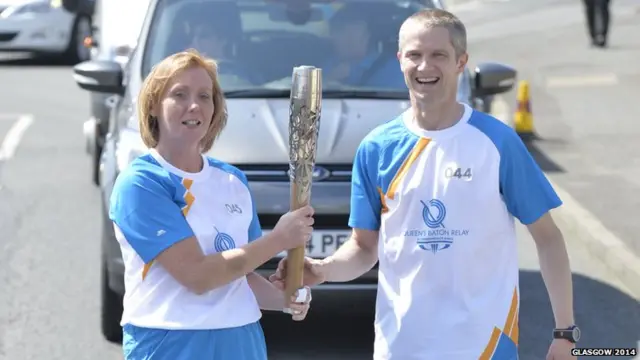 Fiona Grieve and Matthew Cox both grip the Queen's baton