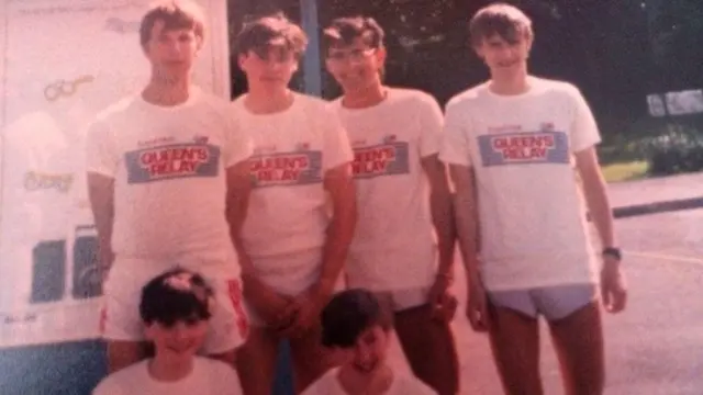 Group shot of 1986 baton bearers in t-shirts and very tight shorts.