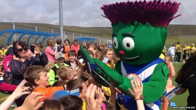 Games mascot Clyde high-fives crowd of children