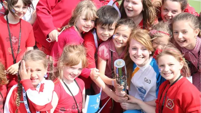 Claire Morris carries the baton at the astroturf pitch in Brae