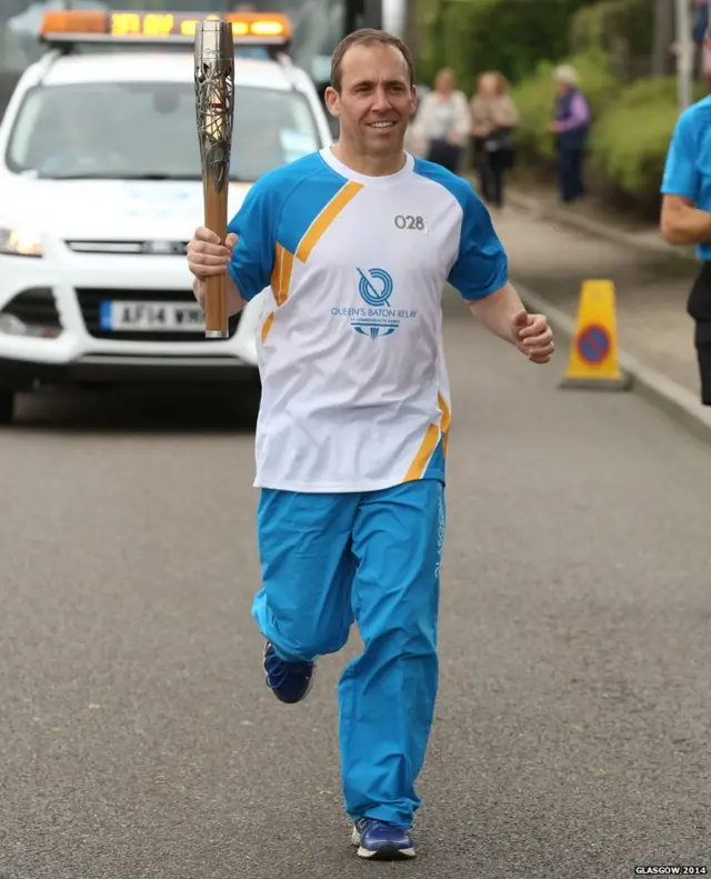 Sam MacPhee runs with Queen's baton