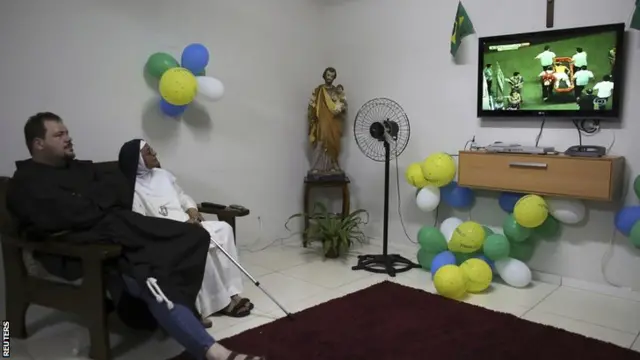 A nun and a priest watch Neymar getting carried off