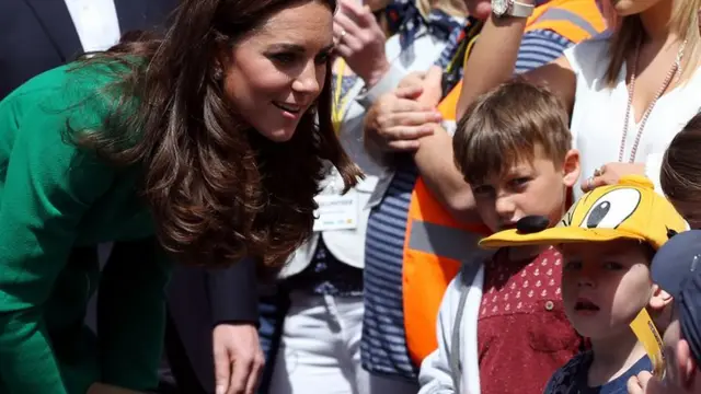 The Duchess of Cambridge chats to children waiting for the Tour in West Tanfield