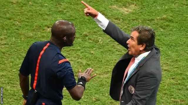 Jorge Luis Pinto of Costa Rica speaks to fourth official Noumandiez Doue