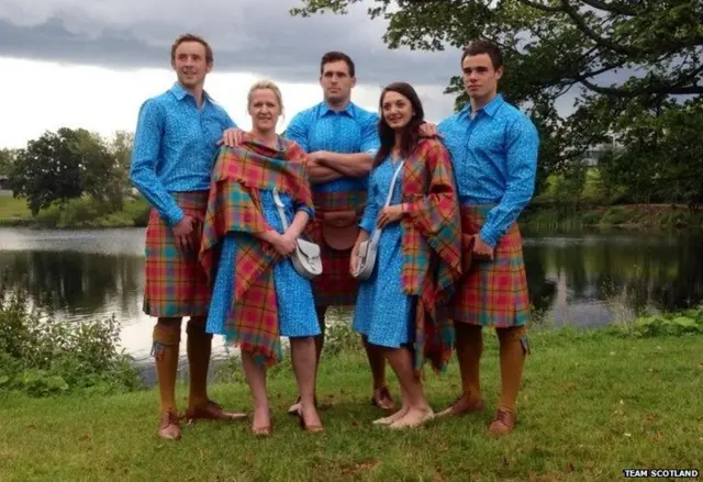 Ladies and gentlemen dressed in tartan kilts and shawls.