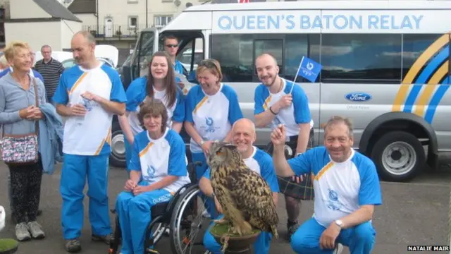 Group of baton bearers with large owl in foreground