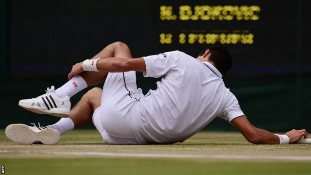 Novak Djokovic holds his ankle