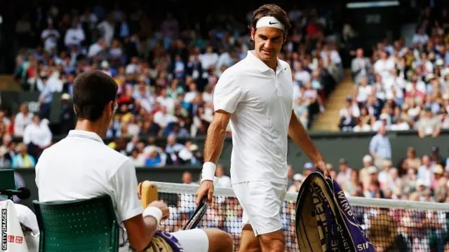 Roger Federer walks past Novak Djokovic