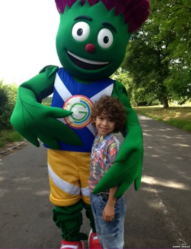 Smiling boy poses with Clyde, the Commonwealth Games mascot