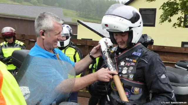 Biker gets Queen's baton strapped to his leather jacket.