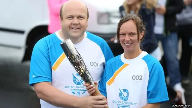 Roland MacPhee, who was the first baton bearer of the day, hands the baton to Christine Lindsay MacQuarrie