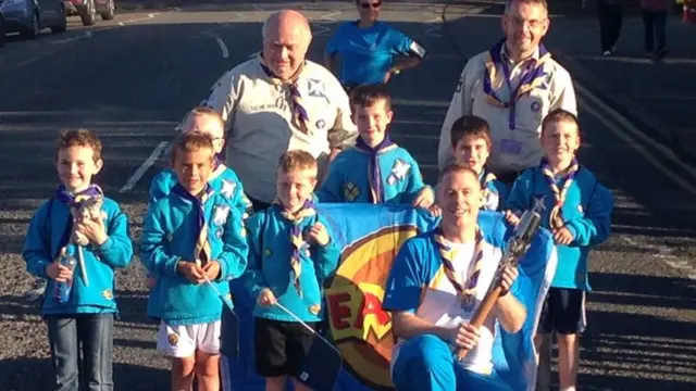 Glenn Denny and local beavers pose with the Queen's Baton