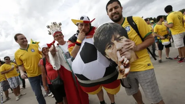 German and Brazilian fans holding a cardboard cutout of Germany's coach Joachim Loew pose outside the Mineirao Stadium