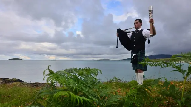 A lone piper carries the Glasgow 2014 Queen's Baton through Daliburgh/Dalabrog on South Uist